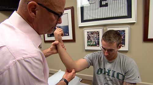 Dr. Kremchek treating an elbow injury in a baseball player