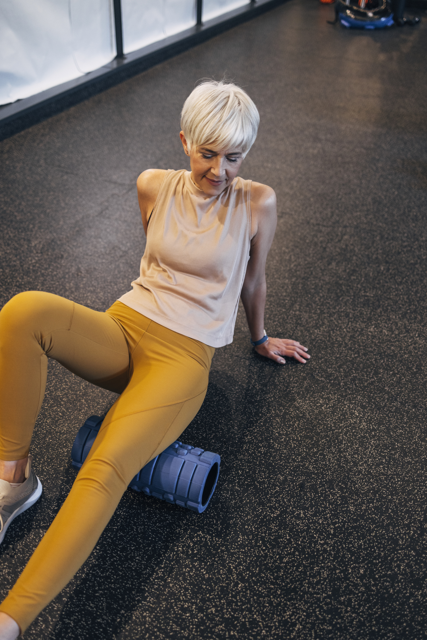 A beautiful female exercising hip mobility in the gym to keep fit.
